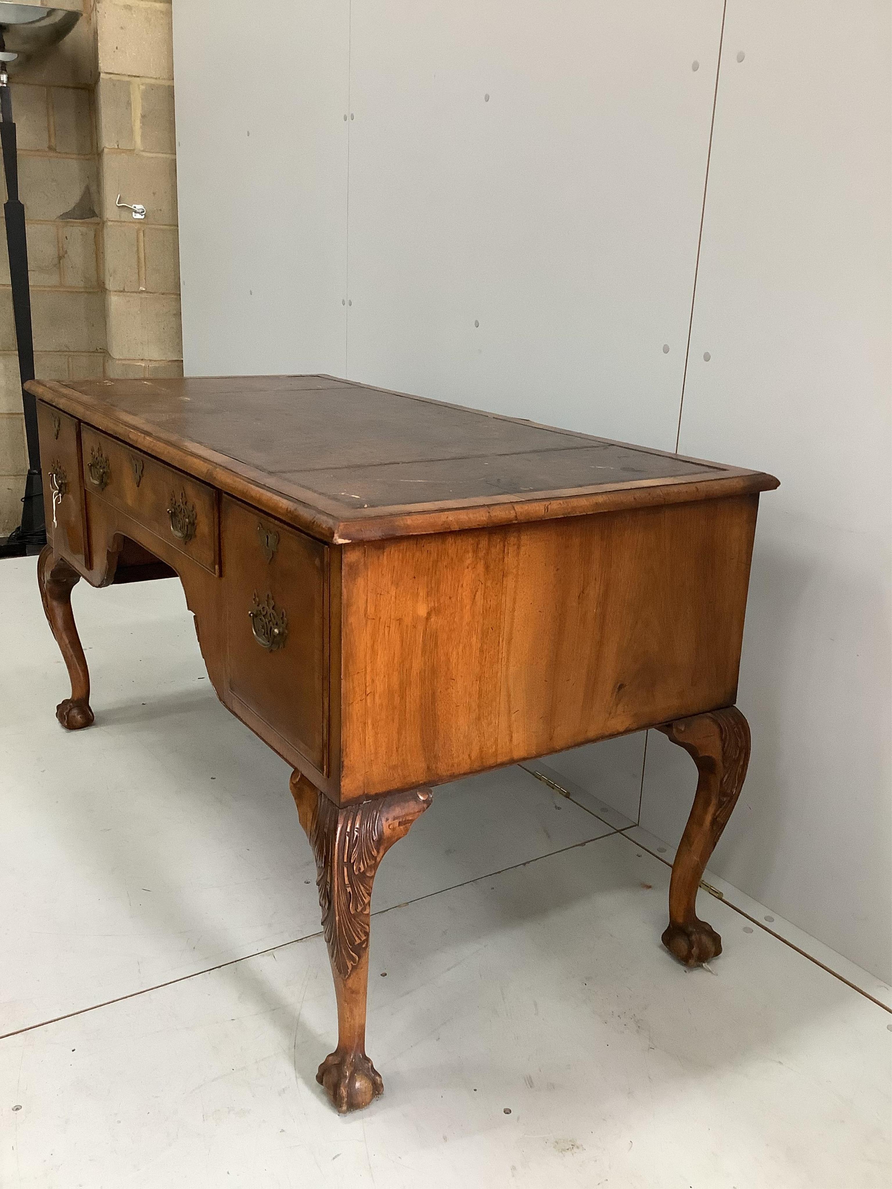 A 1930's walnut kneehole walnut writing table, width 148cm, depth 68cm, height 76cm. Condition - fair to good